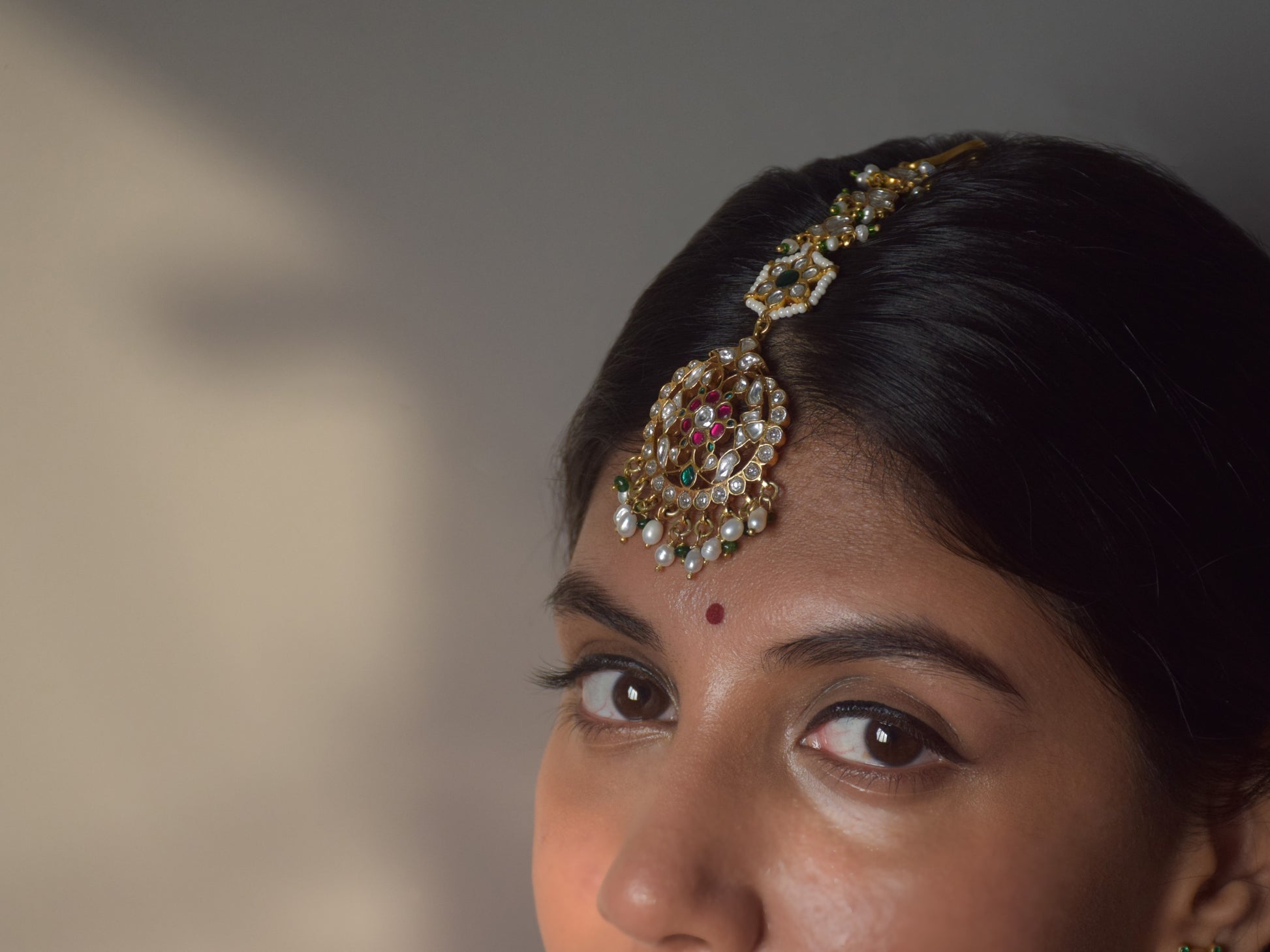 Luxury handcrafted maangtika in 925 silver featuring intricate green, pink, and white Jadau stones with pearl strands.premium 925 sterling silver jewelry
