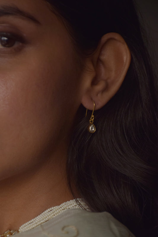 Delicate fish hoop earrings handcrafted in 925 silver, featuring a graceful drop-shaped Jadau stone.