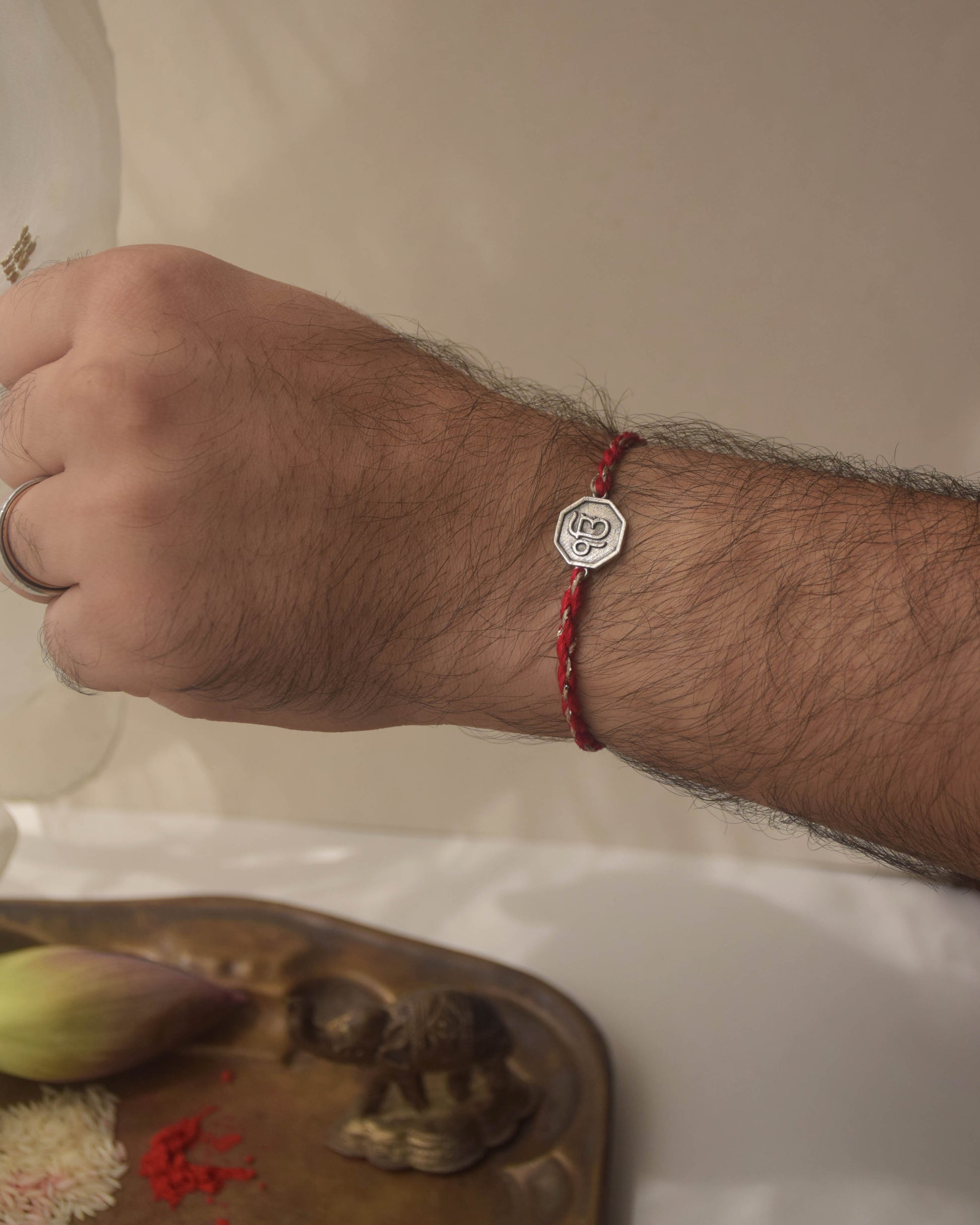 Ek Onkar rakhi in 925 sterling silver with red cotton thread. Comes with complimentary Kumkum & Chawal.