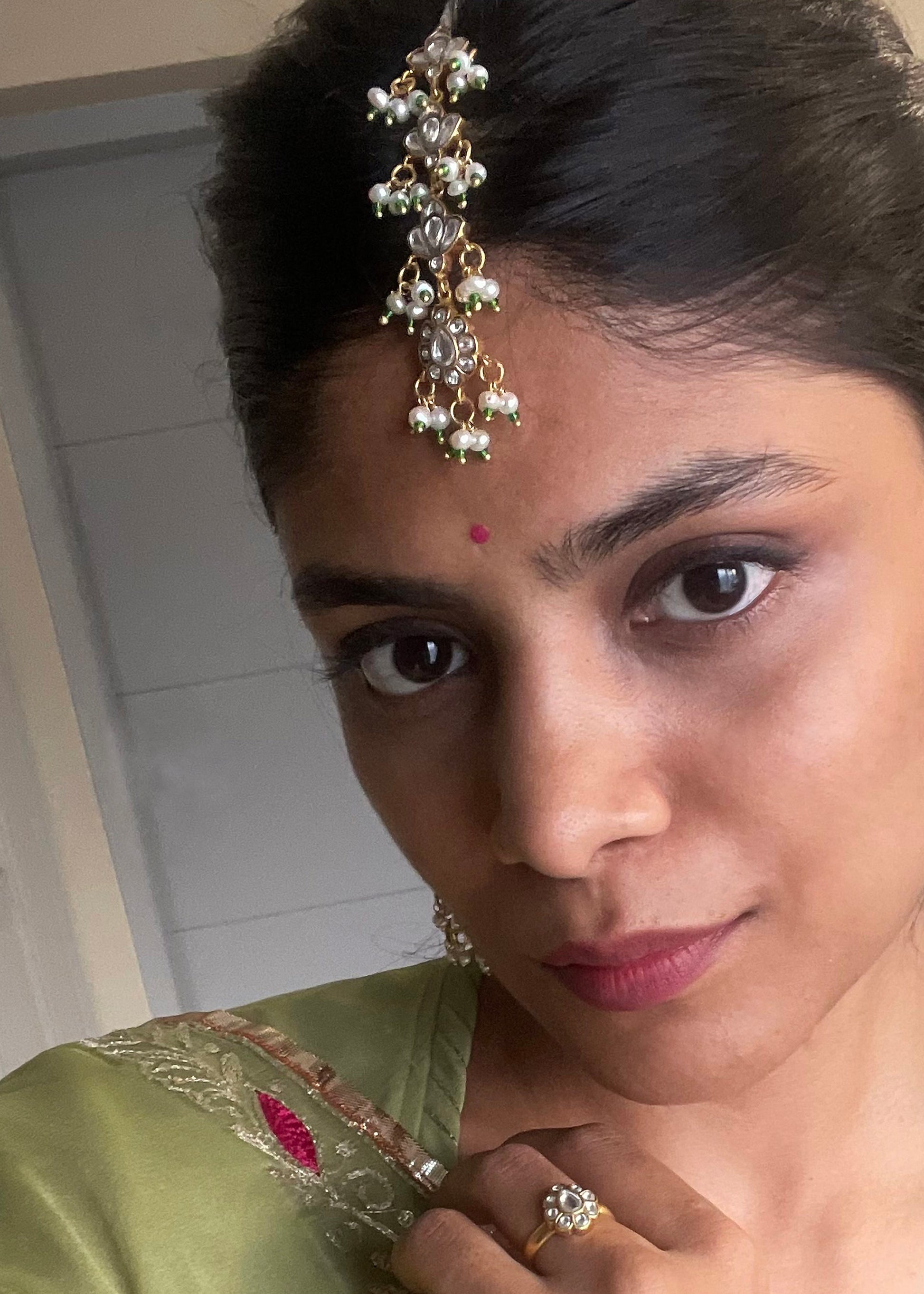 Gold-polished 925 silver maangtika featuring intricate jadau stones and cascading pearl strands for traditional styling. Handcrafted in 925 Silver

