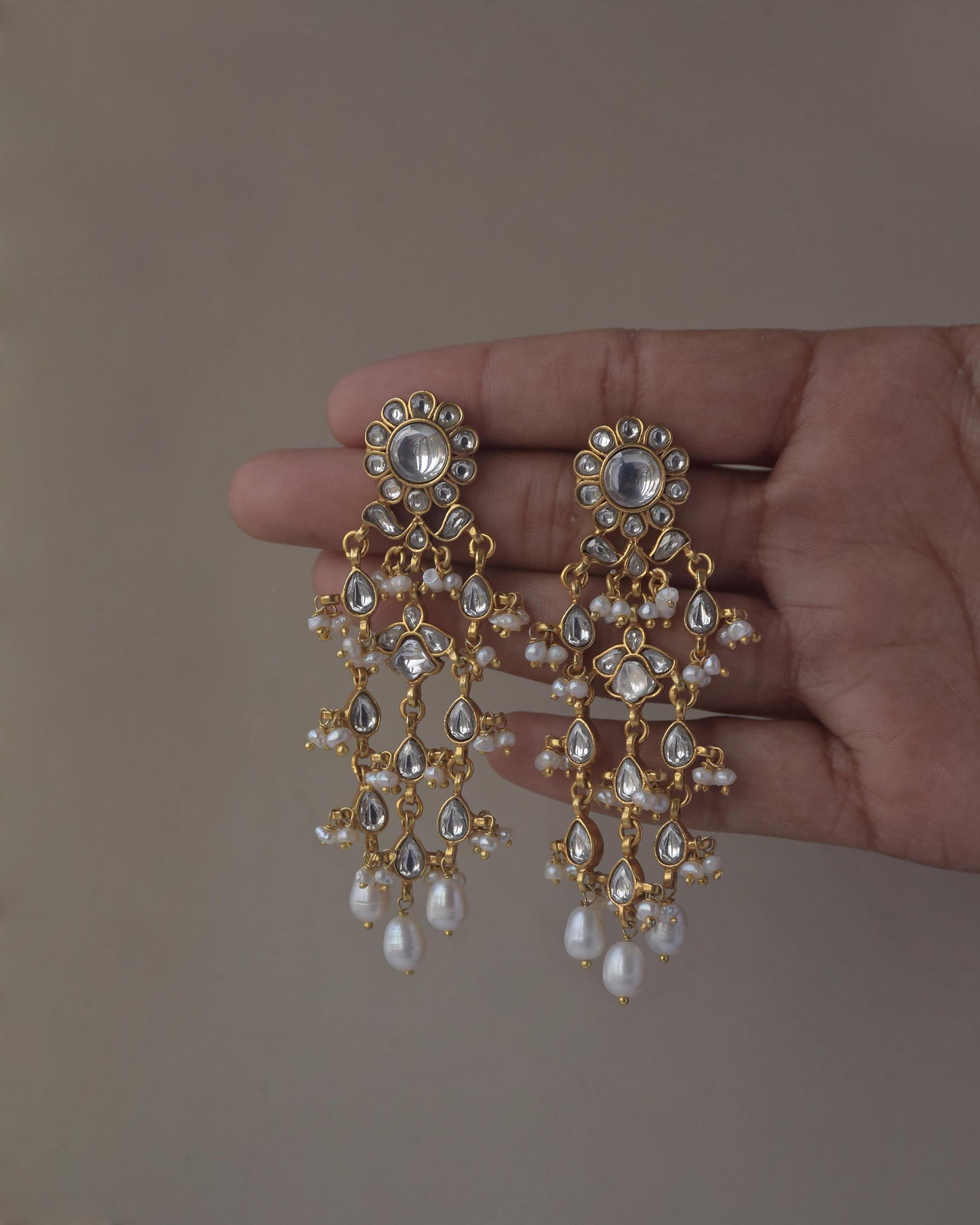 Intricate Jadau earrings with traditional stone work and pearl drops