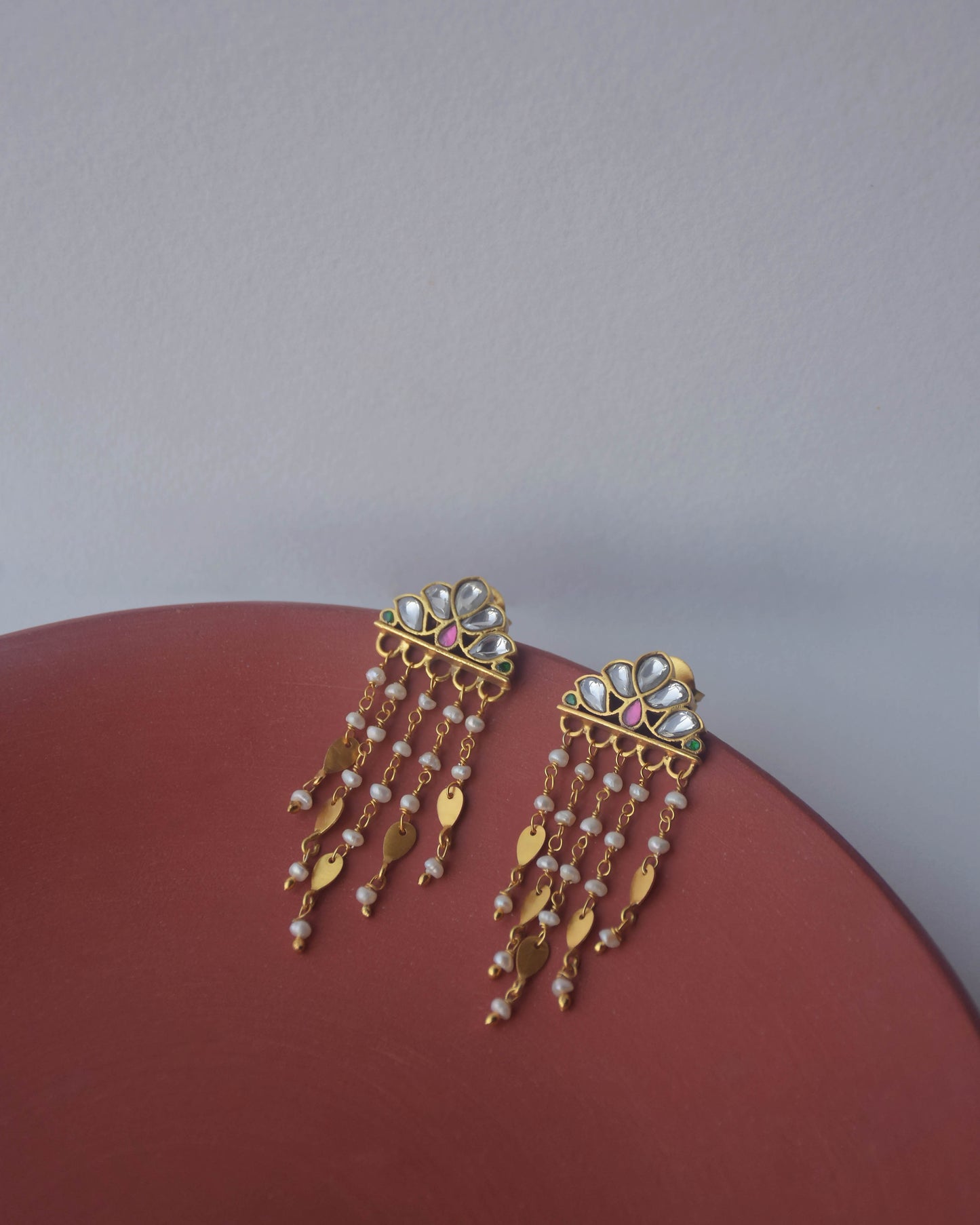 Luxury Jadau earrings with hand-set stones, freshwater pearls, and golden leaf detailing