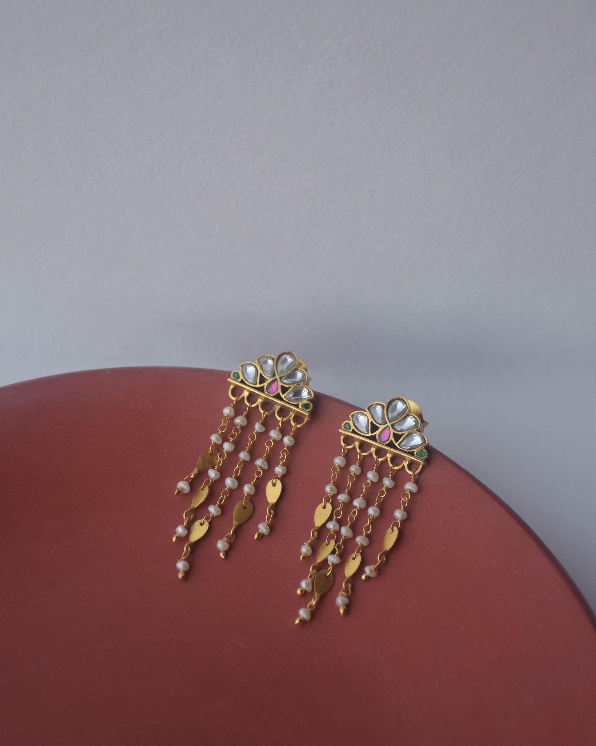 Luxury Jadau earrings with hand-set stones, freshwater pearls, and golden leaf detailing