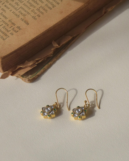 Exquisite fish hoop earrings featuring a 4-petal Jadau stone-studded flower motif adorned with small green AD stones.