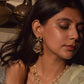  Handcrafted bridal earrings in 92.5 sterling silver, featuring intricate petal motifs adorned with sparkling Jadau cut stones and elegant petal-shaped drops.