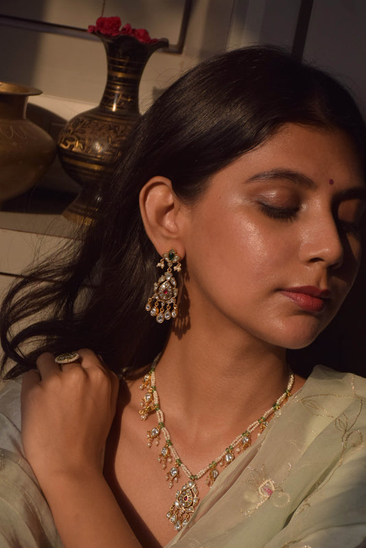  Handcrafted bridal earrings in 92.5 sterling silver, featuring intricate petal motifs adorned with sparkling Jadau cut stones and elegant petal-shaped drops.