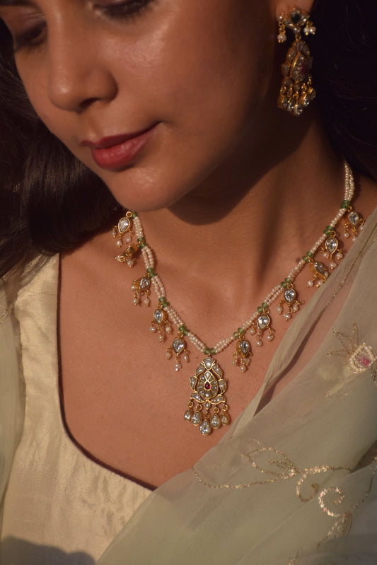 Lalita Jadau wedding necklace handcrafted in 925 silver, featuring a petal-shaped pendant suspended on freshwater pearl strands and adorned with pearl drop-shaped details.