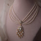 "Lehr Necklace handcrafted in 925 silver with intricate jadau work, featuring a bold central pendant and five strands of freshwater pearls.

