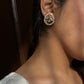 Mayuri 925 silver earstuds with radiant gold polish featuring a peacock design embellished with intricate Jadau stones and delicate seed pearls.