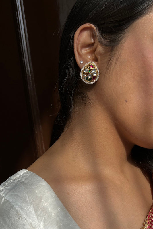 Mayuri 925 silver earstuds with radiant gold polish featuring a peacock design embellished with intricate Jadau stones and delicate seed pearls.