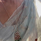 Mayuri pendant in 925 silver with gold polish, featuring a peacock centerpiece adorned with intricate Jadau stones, green strawberry quartz beads, pearls, and pink beads Nuvi Jewels