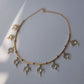 Contemporary hasli design featuring pink beads, floral motifs, and cascading freshwater pearls in gold finish.