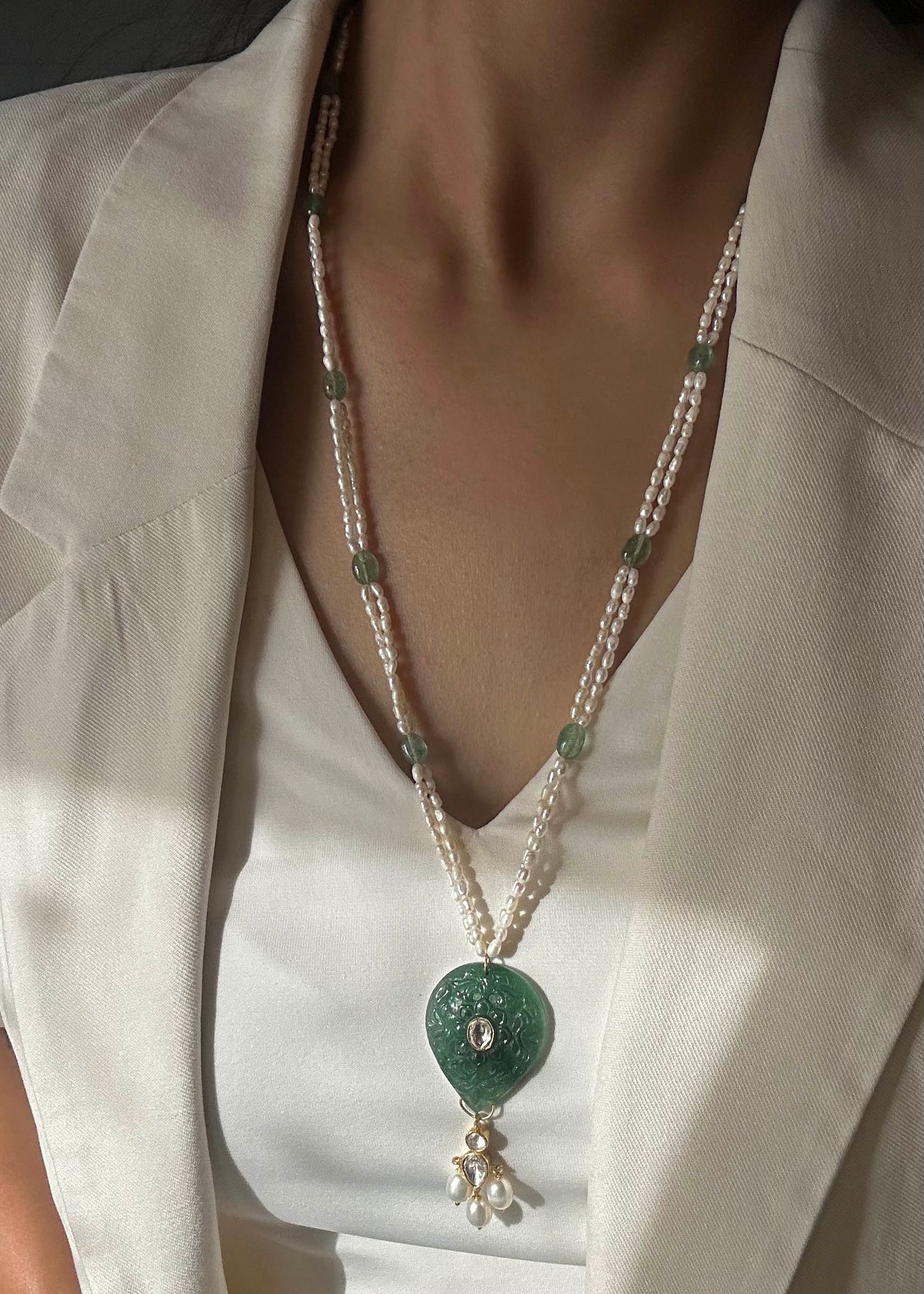 Artisanal Navya long necklace made of hallmarked 925 silver, showcasing a unique hand-carved green quartz stone and delicate polki, on a premium freshwater rice pearl mala.