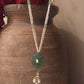 Navya long necklace handcrafted in 925 sterling silver, featuring a hand-carved green quartz pendant with intricate polki detailing, elegantly strung on a freshwater rice pearl mala.