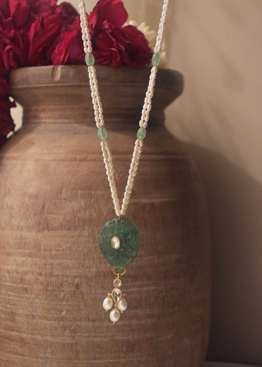 Navya long necklace handcrafted in 925 sterling silver, featuring a hand-carved green quartz pendant with intricate polki detailing, elegantly strung on a freshwater rice pearl mala.