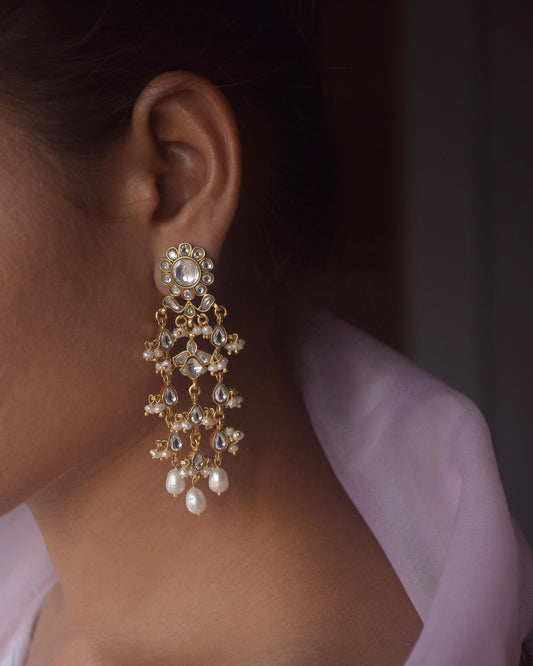Elegant Jadau earrings featuring intricate traditional Indian craftsmanship, adorned with sparkling polki stones and lustrous freshwater pearls