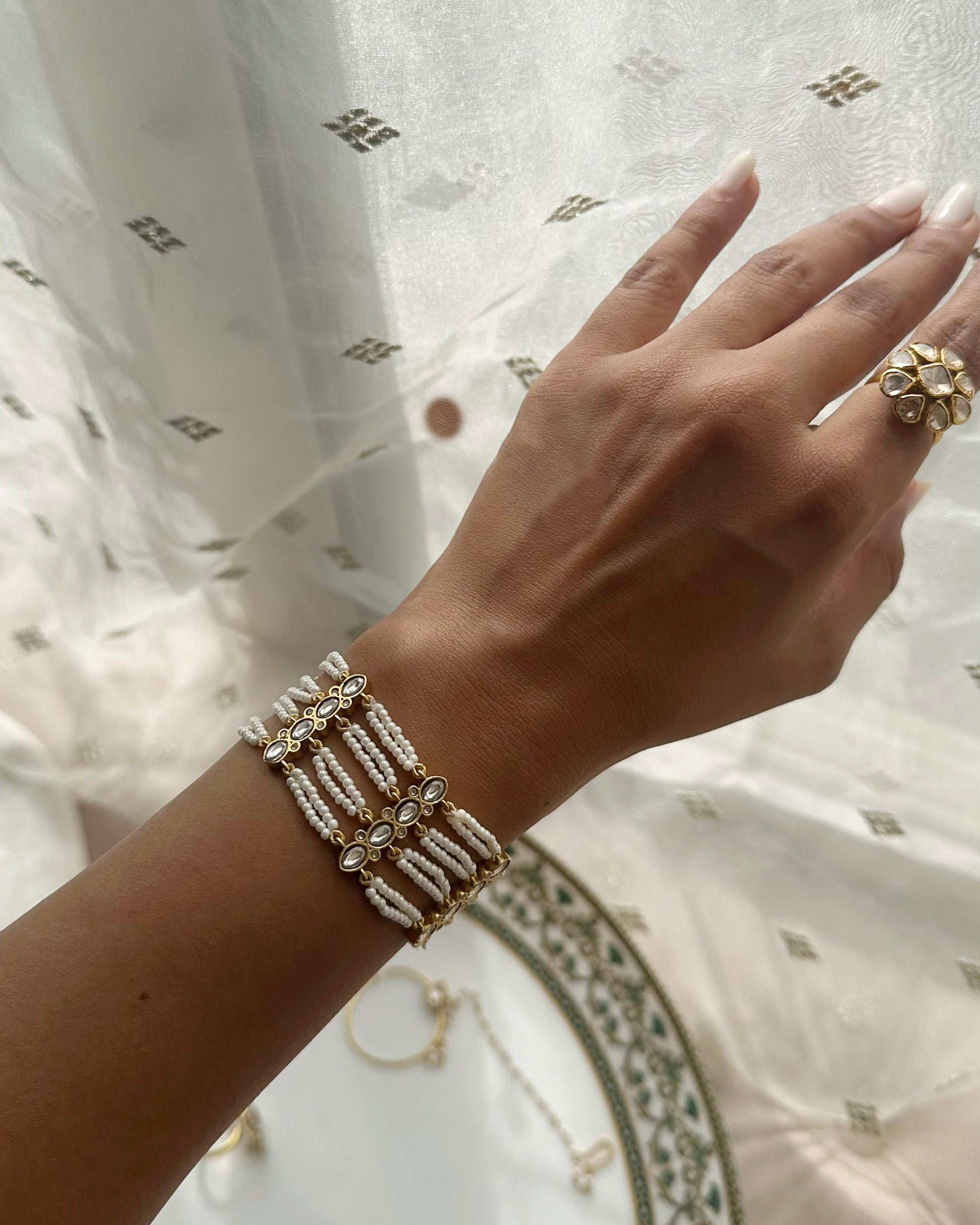 Radhika Bracelet featuring a radiant fusion of lustrous pearls and a captivating Jadau unit.Shop Premium 925 Silver Jewellery for Women