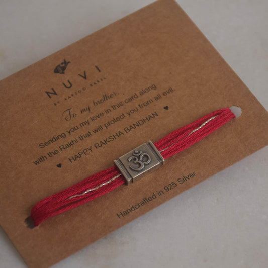 Red cotton thread Rakhi with silver Om charm on a NUVI branded card