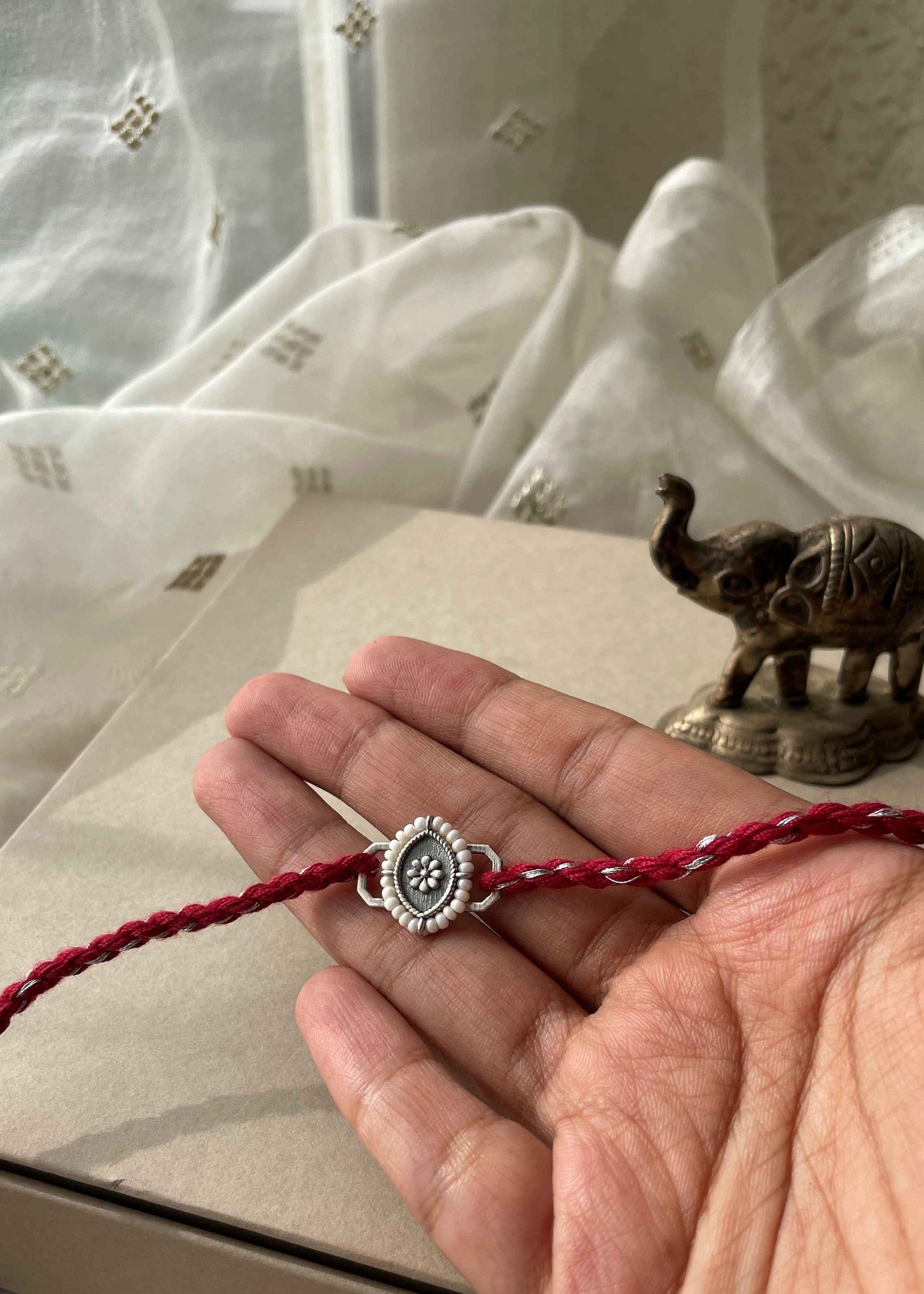 Handcrafted 92.5 sterling silver rakhi with elegant Nauka charm detailing