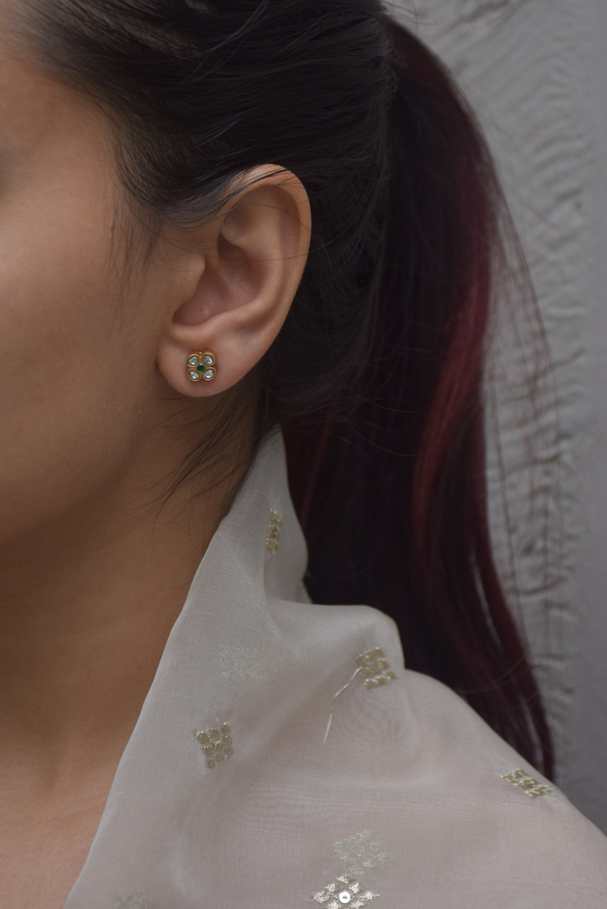 Raatrani 925 silver earstuds with 22k gold plating and delicate Jadau stone-studded flower motif.