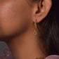 Raatrani Hoop Earrings crafted from 925 silver with 22-carat gold plating, featuring a 4-petal Jadau stone-studded flower motif hanging from the hoop.