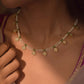 Raina Necklace handcrafted in 925 silver with four-petal floral motifs embellished with white jadau stones, strung on freshwater pearls with adjustable dori.