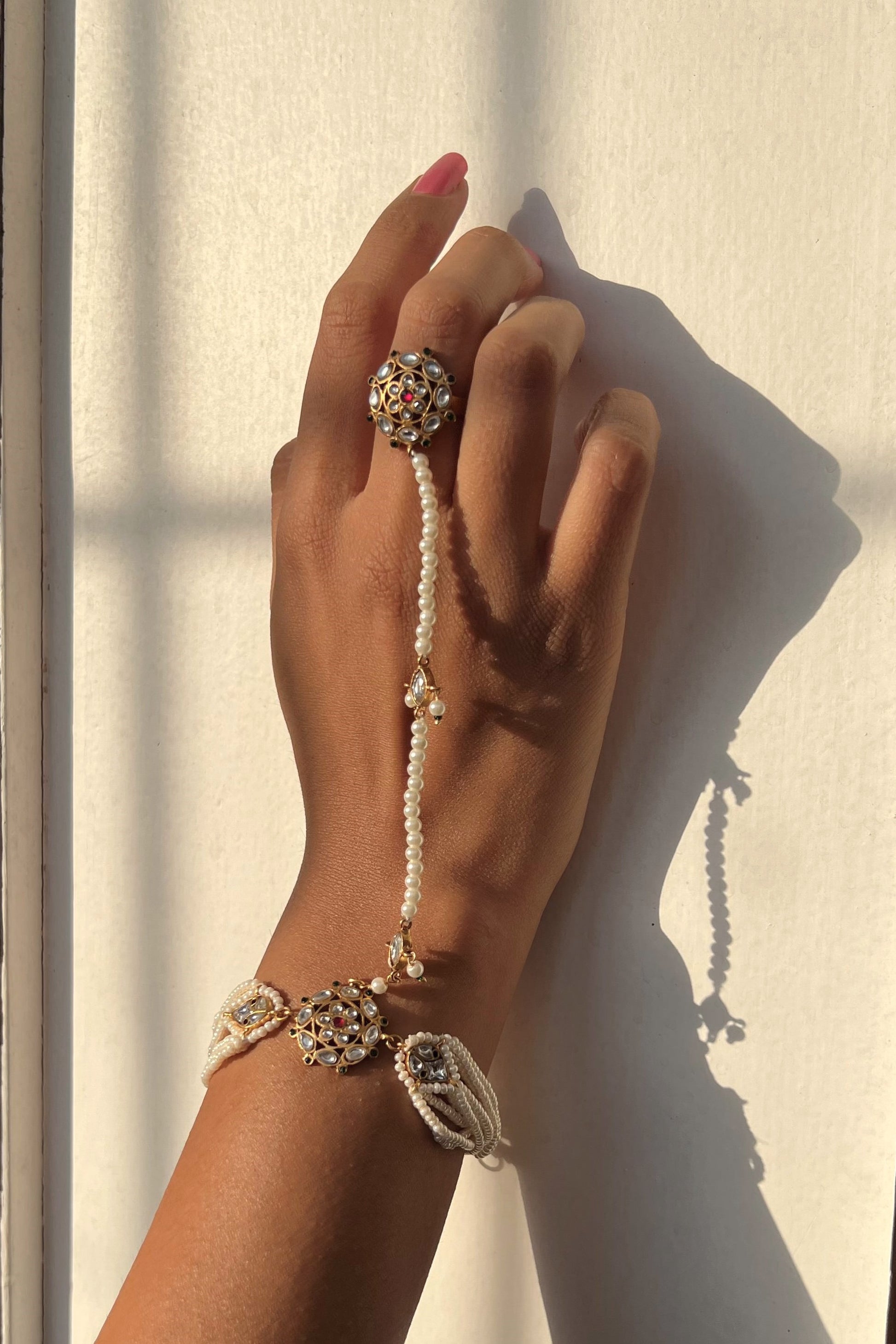 Ranisa Haathphool handcrafted in 925 silver featuring a finger ring connected to an elegant string of pearls.