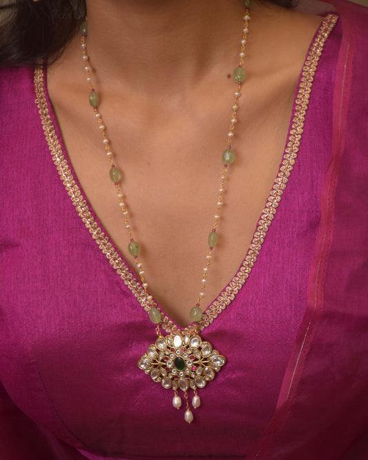 "Rasiya pendant necklace handcrafted in 925 silver, featuring intricate white Jadau polkis, glass-filled stones, and suspended rice pearls.