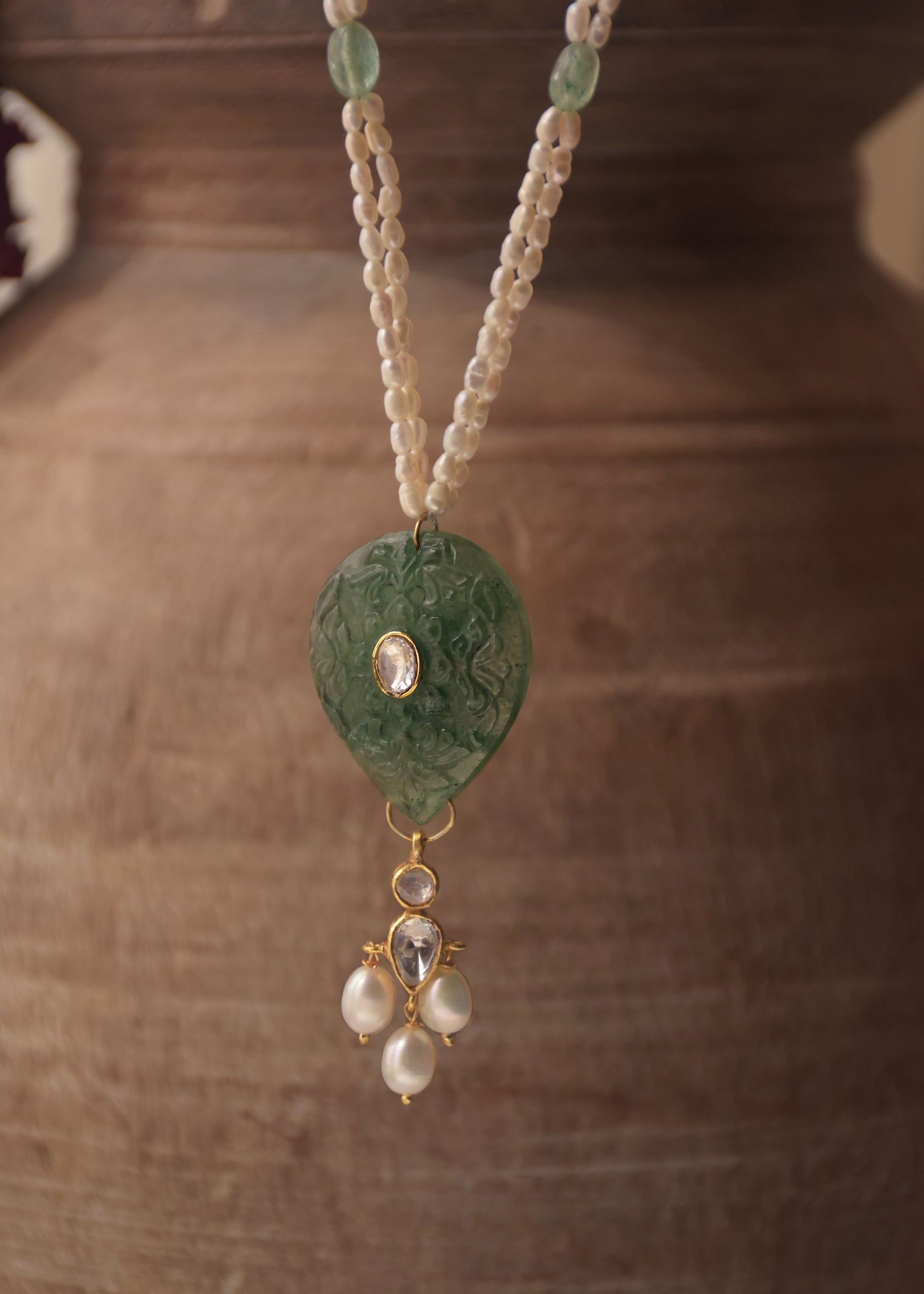Artisanal Navya long necklace made of hallmarked 925 silver, showcasing a unique hand-carved green quartz stone and delicate polki, on a premium freshwater rice pearl mala.