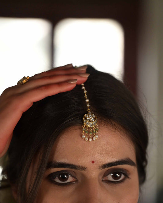 Suratiya Maangtika handcrafted in 925 silver featuring a traditional chaand motif adorned with delicate rice pearls and green aventurine beads.