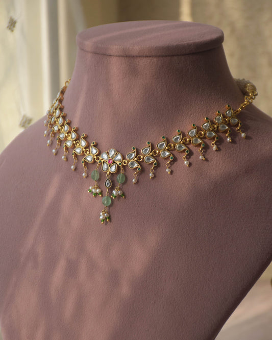 Vanya necklace handcrafted in 92.5 sterling silver, featuring intricate Jadau work and a flowing line of paisley motifs, elegantly finished with dangling pearl drops.