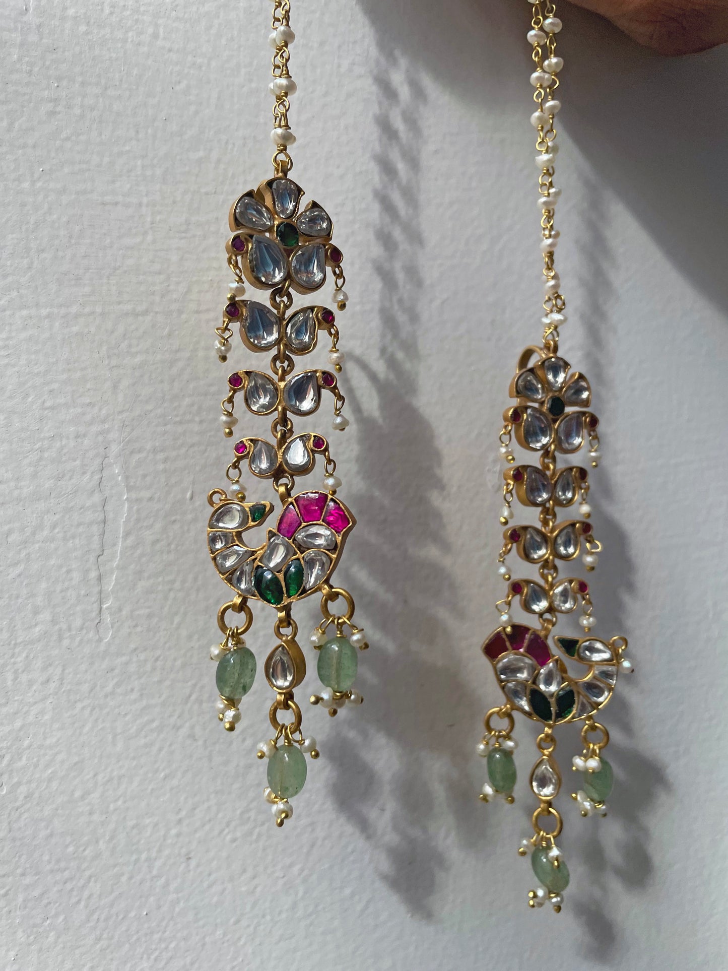 Nuvi Jewels Laila Kaanchain Earrings, handcrafted in sterling silver with gold finish, showcasing peacock studs, delicate paisley motifs, and a pearl chain for adjustable styling.